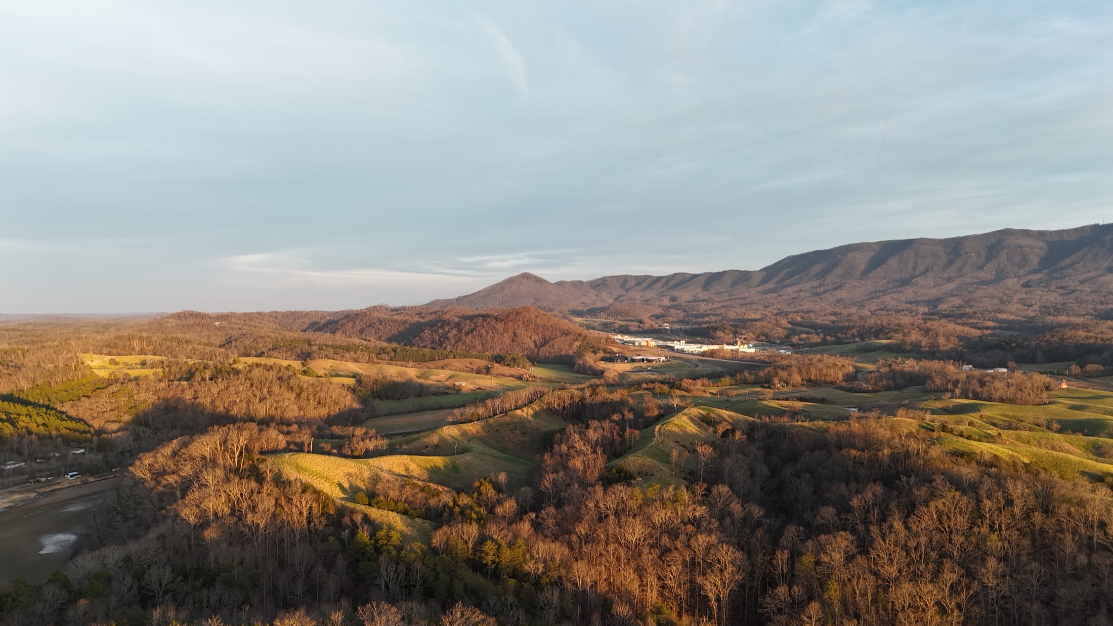 Golden-hour drone view of rolling foothills near the Smokies